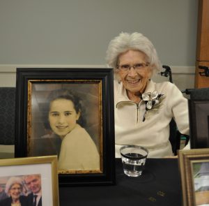 Resident Florence Spinelli poses with photos from her memory table