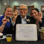 Resident Matthew Cornelia celebrates being a Centenarian with Chapel Oaks employees Mackenzie and Morgan