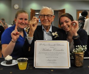 Resident Matthew Cornelia celebrates being a Centenarian with Chapel Oaks employees Mackenzie and Morgan